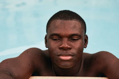 Havuzda poz veren genç yakışıklı adam.