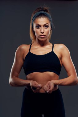 Stüdyoda poz veren genç sporcu kadın vücut geliştirici. 