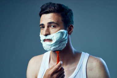 Genç ve yakışıklı bir adamın traş olurken çekilmiş bir fotoğrafı. 