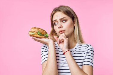  Soyutlanmış arka planda hamburgeri olan güzel üzgün kadın. 