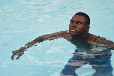 Havuzda poz veren genç yakışıklı adam.