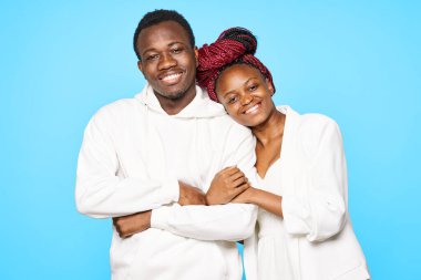 Stüdyoda mavi arka planda poz veren genç ve güzel bir çift