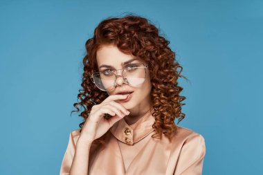 Stüdyoda poz veren gözlüklü güzel bir kadın.