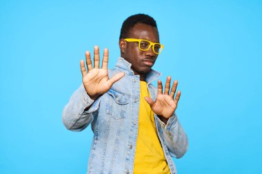 Genç Afrikalı adam mavi arka planda izole edilmiş.