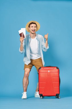 Genç turist stüdyoda başparmağını gösteren biletlerle.