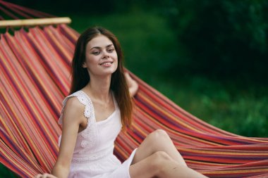 Genç ve güzel bir kadın hamakta dinleniyor. 