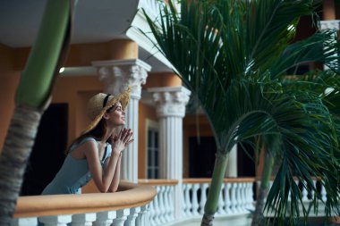   Tropik tatil köyünde hasır şapkalı genç bir kadın. 