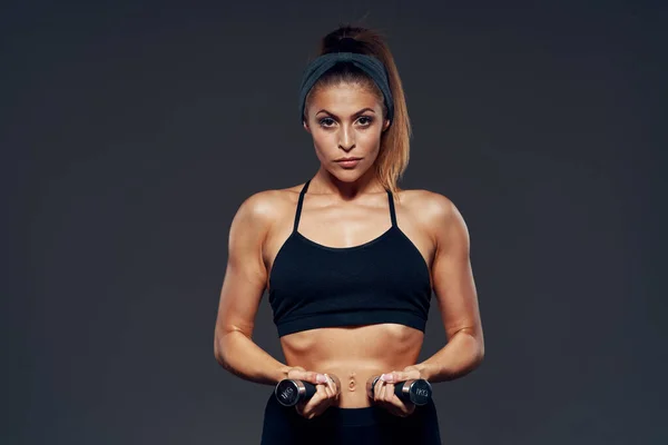 stock image yomg woman lifting dumbbells, studio shot