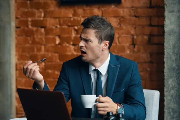 若いですハンサムな怒っているビジネスマンとともにコーヒーカップ — ストック写真