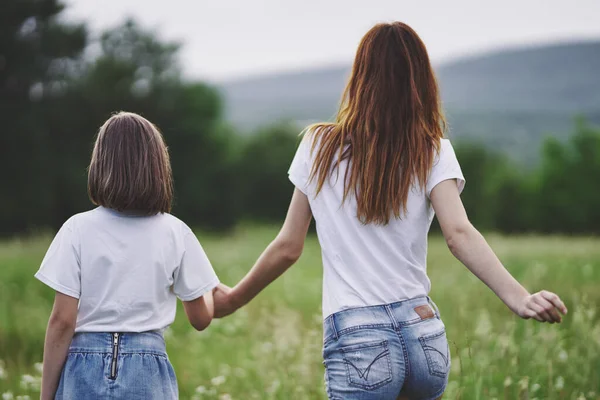 Genç anne ve kızı papatya tarlasında eğleniyorlar.