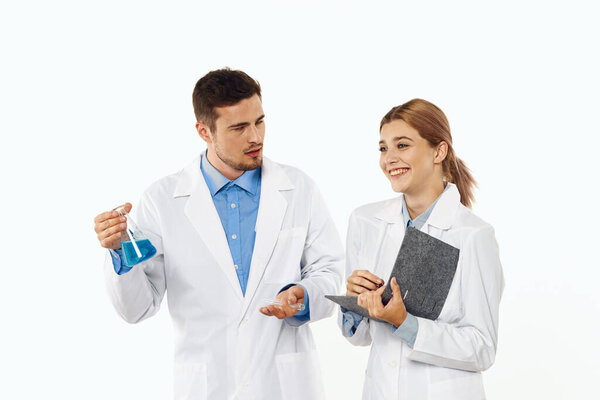 Studio shot. Young doctor and nurse  with flask on isolated background