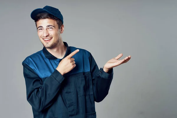 Joven Guapo Hombre Uniforme Azul Mostrando Algo —  Fotos de Stock