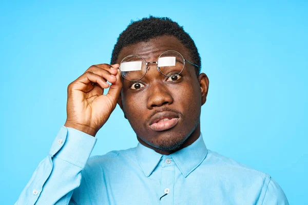 Joven Africano Posponiendo Gafas Aisladas Sobre Fondo Azul —  Fotos de Stock