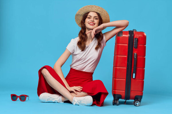 young woman  tourist with red suitcase in studio             