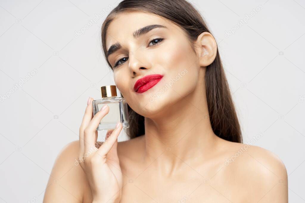 portrait  of young beautiful woman with perfume bottle  isolated 