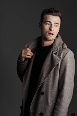 Siyah arka planda ceketli genç bir adamın portresi.  