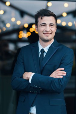 Kollarını kavuşturup poz veren genç yakışıklı adam. 