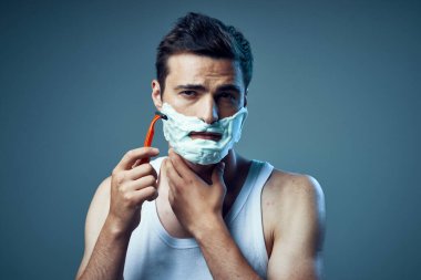 Genç ve yakışıklı bir adamın traş olurken çekilmiş bir fotoğrafı. 