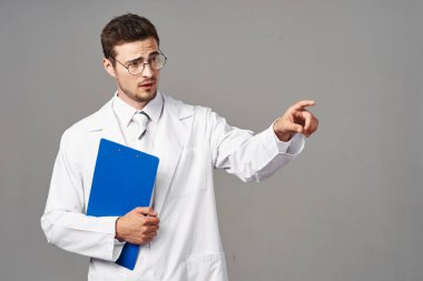 Stüdyo çekimi. Genç doktor izole bir geçmişe işaret ediyor. 