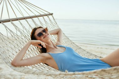 Genç ve güzel bir kadın hamakta dinleniyor. 