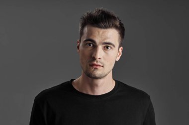 Stüdyoda poz veren yakışıklı genç adamın portresi. 