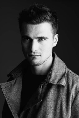 Stüdyoda poz veren ceketli genç yakışıklı adam. 