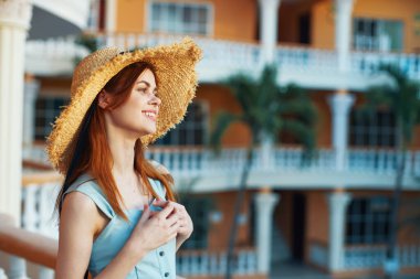   Tropik tatil köyünde hasır şapkalı genç bir kadın. 