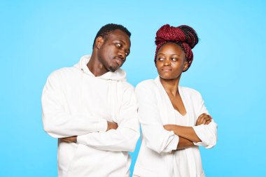 Stüdyoda mavi arka planda poz veren genç ve güzel bir çift