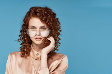 Stüdyoda poz veren gözlüklü güzel bir kadın.