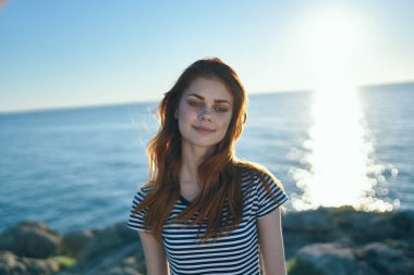 Sahilde poz veren güzel genç bir kadın. 