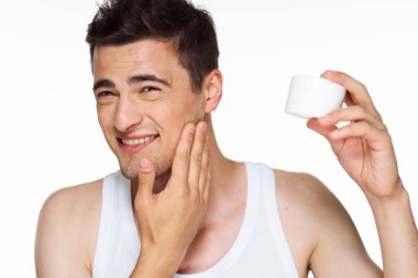 Beyaz arka planda kremalı genç ve yakışıklı bir adamın stüdyo fotoğrafı. 