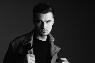 Stüdyoda poz veren ceketli genç yakışıklı adam. 