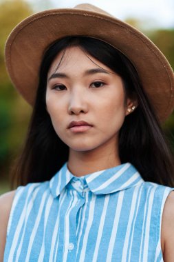 Parkta poz veren genç bir kadın. 