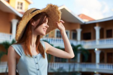   Tropik tatil köyünde hasır şapkalı genç bir kadın. 