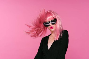 Pembe peruklu kadın, pembe arka planda saç ve güneş gözlüğü.