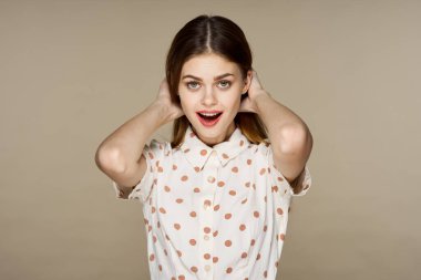  Bej arka planda yalnız poz veren güzel bir kadın.  