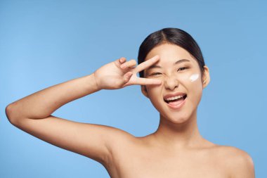 Genç Asyalı kadın mavi arka planda stüdyoda jest yapıyor. 