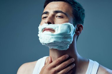 Genç ve yakışıklı bir adamın traş olurken çekilmiş bir fotoğrafı. 