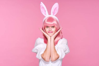 Pembe peruklu ve pembe arka planda tavşan kulaklı güzel bir kadının sudio çekimi.