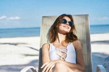  Genç bir kadın kumsalda güneşleniyor.              