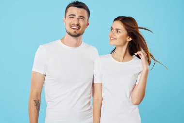 Stüdyoda izole edilmiş arka planda poz veren tişörtlü güzel bir çift.  