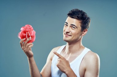 Genç adam izole edilmiş arka planda, stüdyoda havluyu işaret ediyor. 