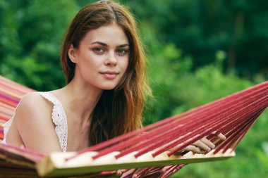 Genç ve güzel bir kadın hamakta dinleniyor. 