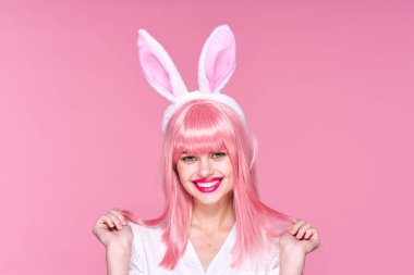 Pembe peruklu ve pembe arka planda tavşan kulaklı güzel bir kadın.