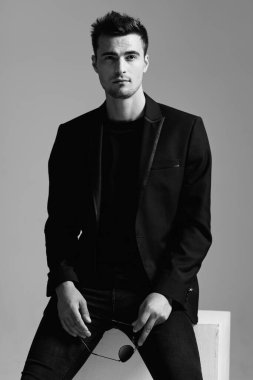 Güneş gözlüğü tutan yakışıklı beyaz bir adam.