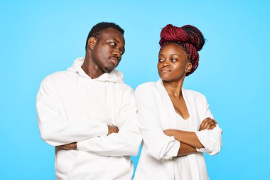 Stüdyoda mavi arka planda poz veren genç ve güzel bir çift