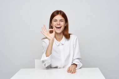  İş kadını ofiste oturmuş el kol hareketi yapıyor. 