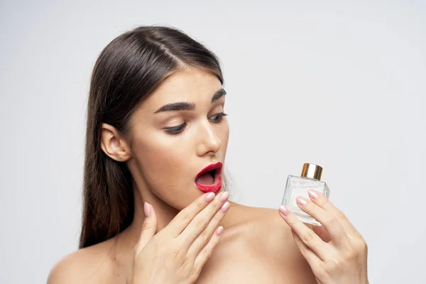 portrait  of young beautiful woman with perfume bottle  isolated