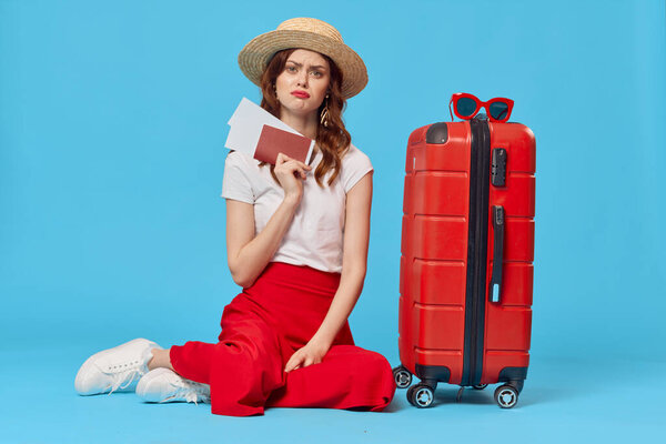 young woman  tourist with red suitcase in studio             