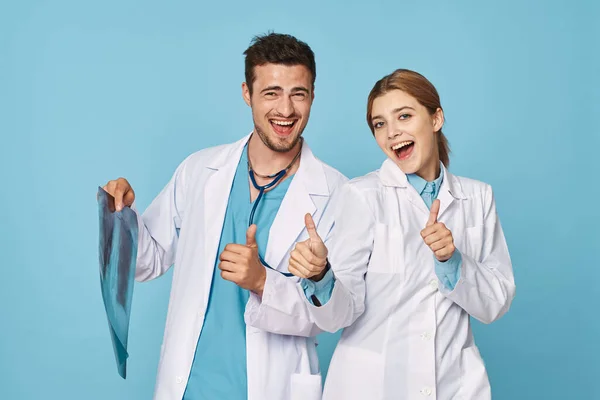 Studioaufnahmen Junge Ärztin Und Krankenschwester Mit Röntgenbild Auf Blauem Grund — Stockfoto